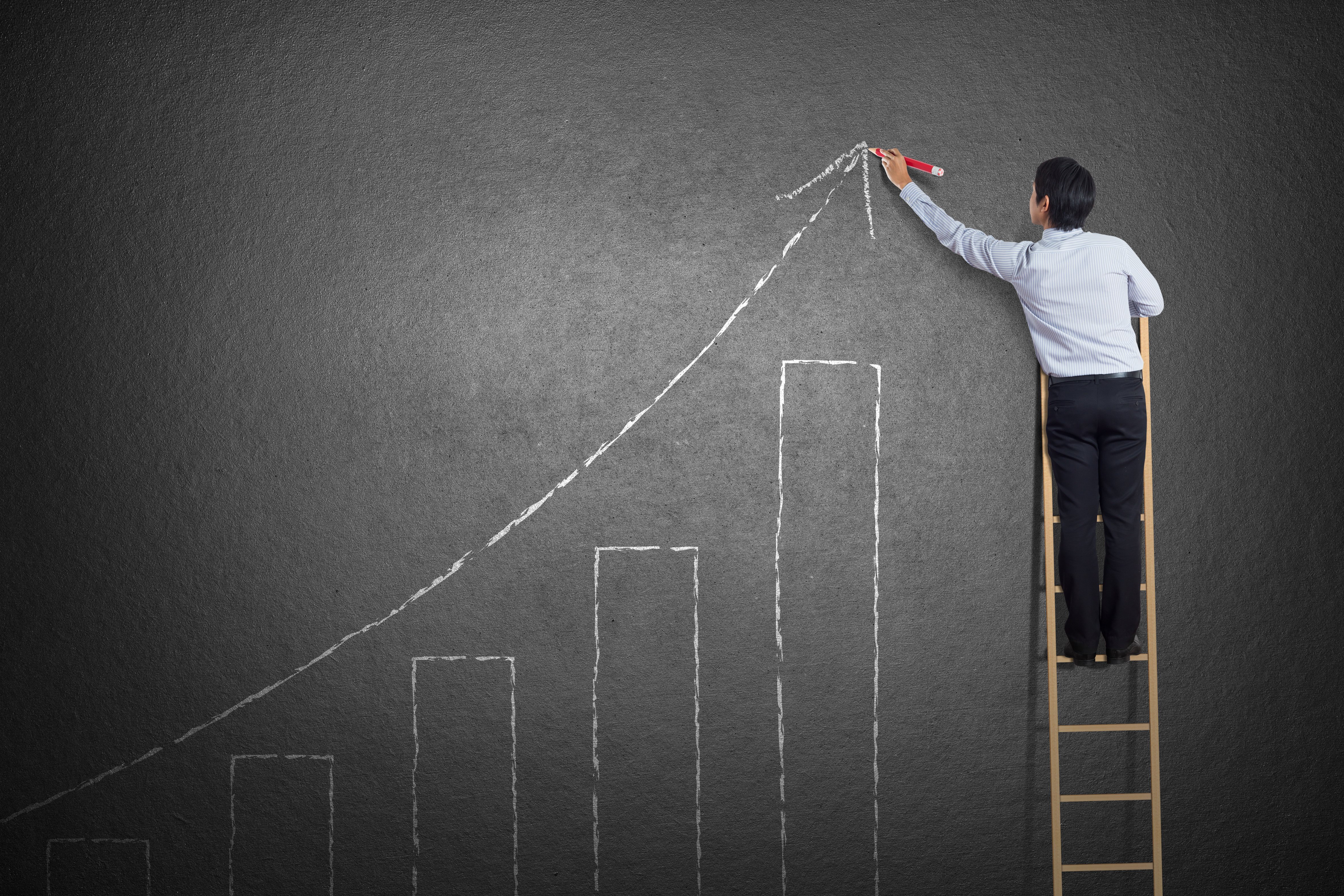 Business Development Manager drawing a growth chart on a blackboard, symbolising career advancement and success